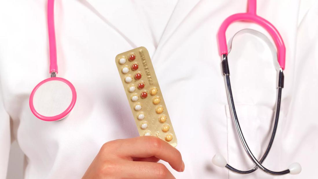 Healthcare provider holding packet of birth control pills