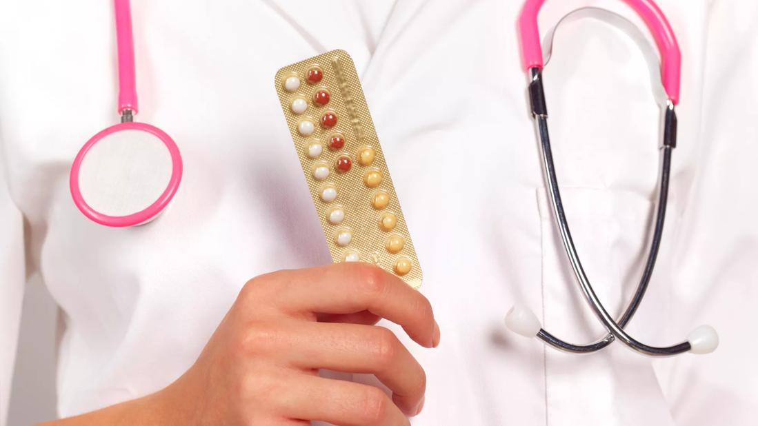 Healthcare provider holding packet of birth control pills