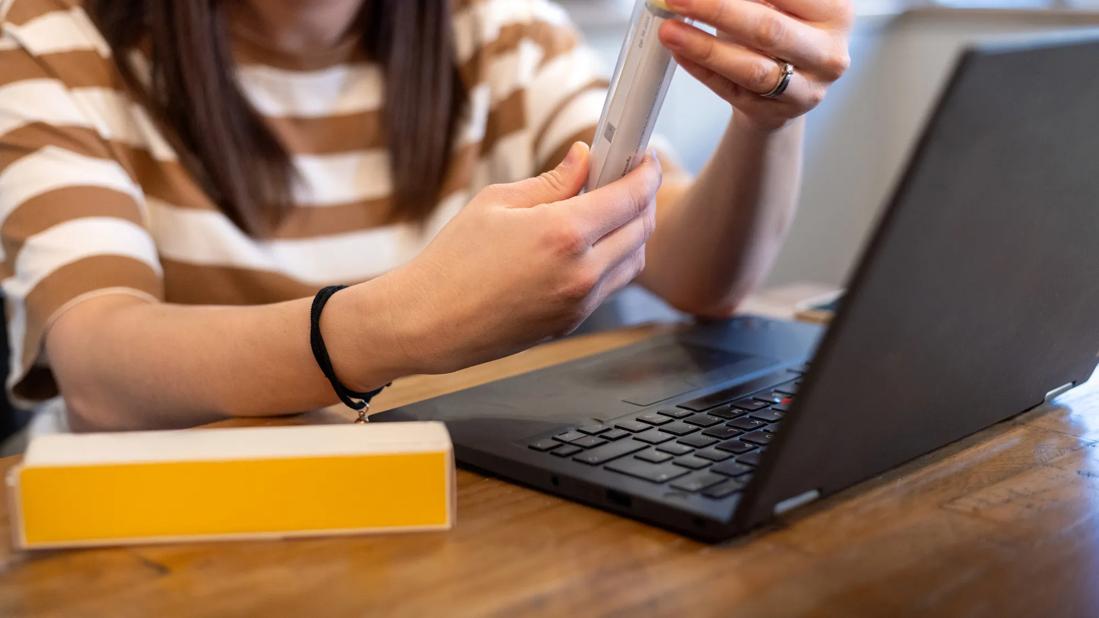 Person on a virtual call with doctor while holding up an Epipen