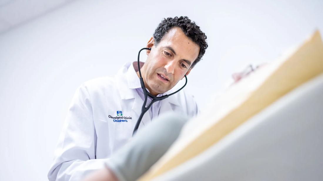 Dr. Peter Aziz with a stethoscope in a clinical exam