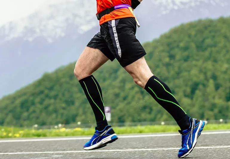 man running while wearing compression socks