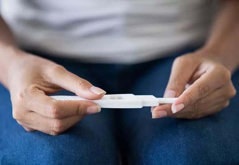 Woman holding a pregnancy test.