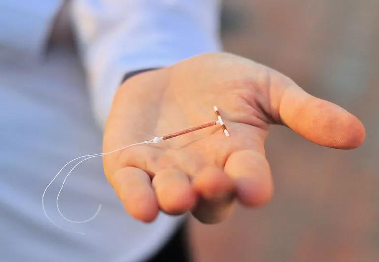 woman holding IUD