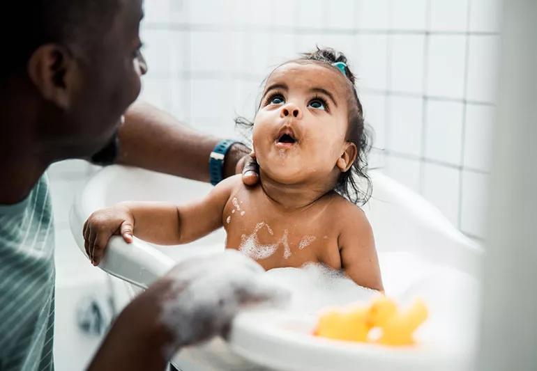 father bathes daughter in bath