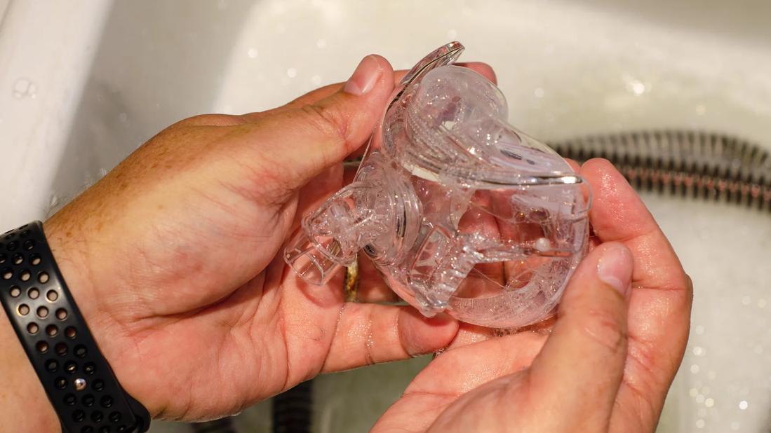 Hands cleaning parts of a CPAP in soapy water