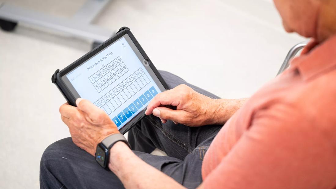 older man taking cognitive test on computer tablet