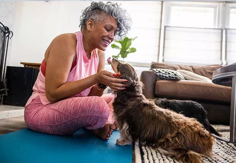 Middle-aged woman on yoga mat at home.