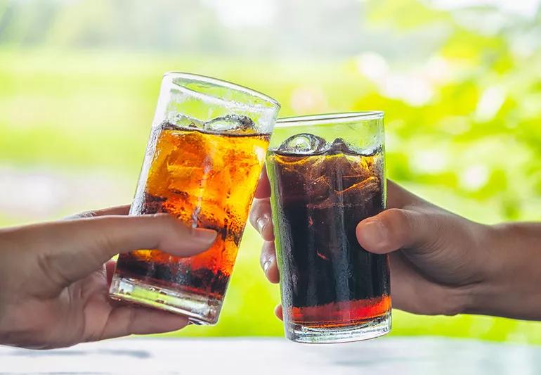 Two glasses of soda on a bright background