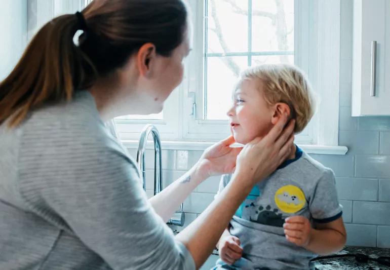 Mom checking on son's earache at home