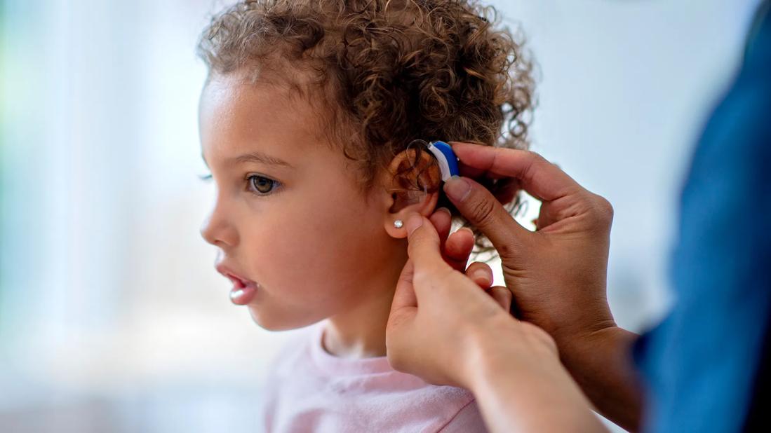 Child being fitted with a hearing aid