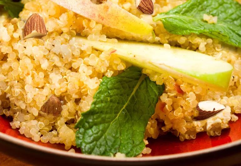 A plate of quinoa with apples, mint leaves and almonds