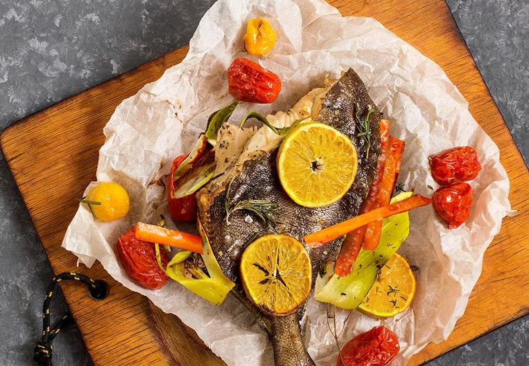 Flounder baked in parchment with veggies and lemon