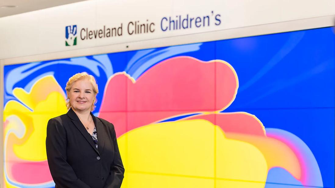 Physician Karen Murray stands in front of Cleveland Clinic Children's signage