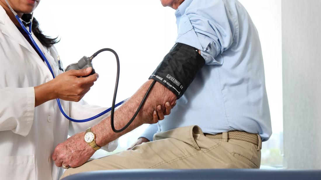 Physician taking a man's blood pressure.
