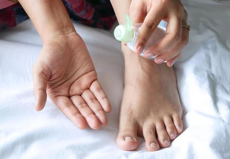 Applying coconut oil to feet to moisturize.