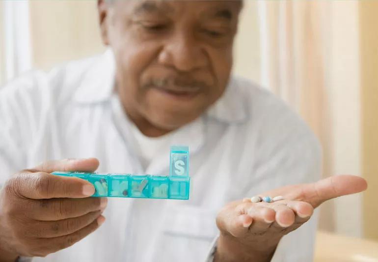 Elderly man taking his daily medications