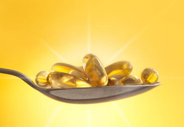 Vitamin D capsules backlighted by sunlight