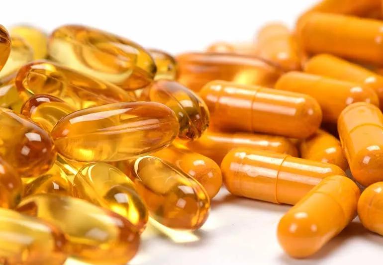 Natural vitamin capsules of turmeric and fish oil.