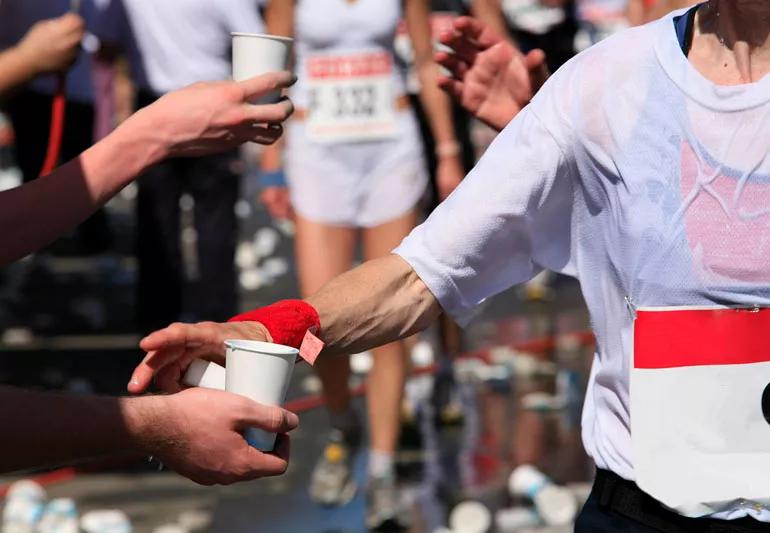 Athletes drinking water and electrolytes during a marathon