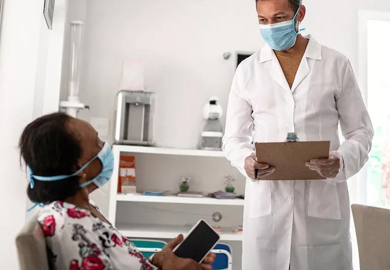 caregiver speaking with a patient in a doctor's office