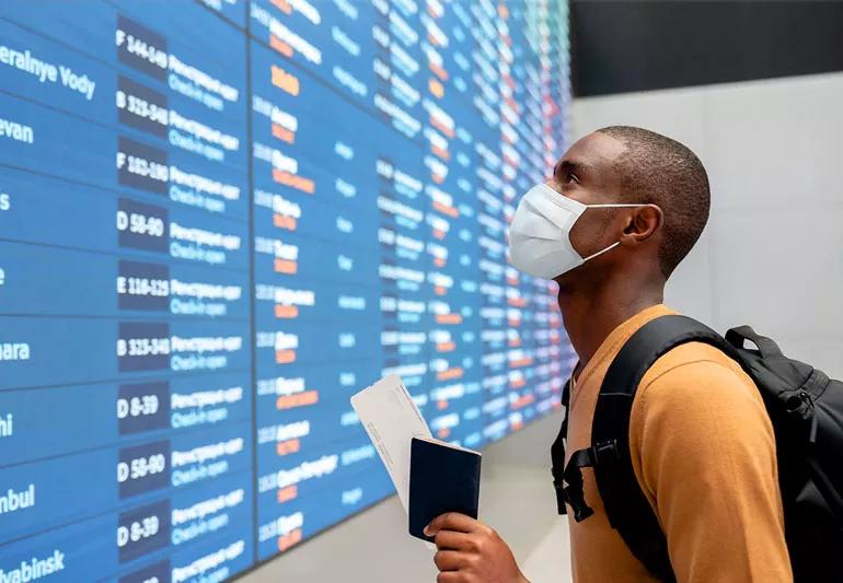 man with mask traveling in airport during pandemic