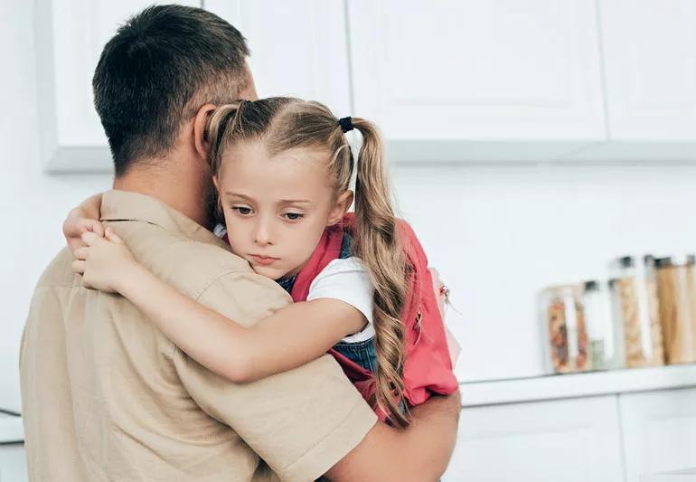 Daughter hugging dad after upsetting day at school