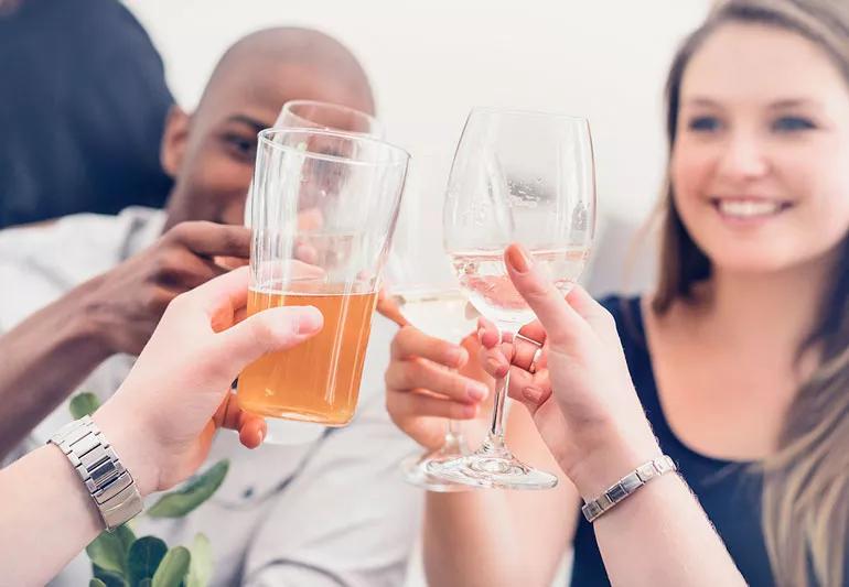 Friends toasting with a variety of drinks including water