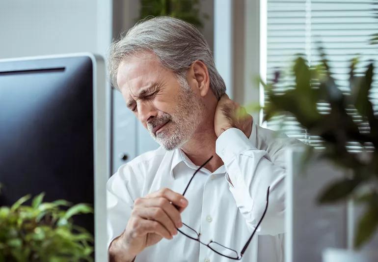 Man at computer suffering neck pain