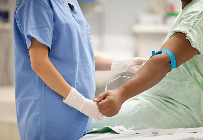 Nurse drawing blood from female patient.