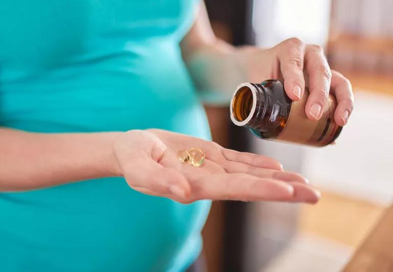 Pregnant woman taking an energy supplement.