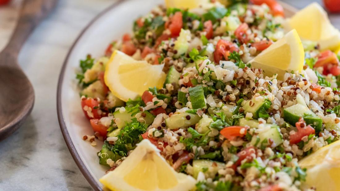 Bowl of gluten-free quinoa tabbouleh, with lemon wedges