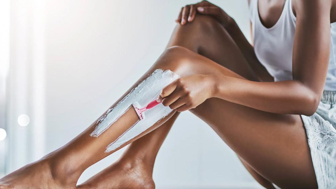 woman shaving her legs