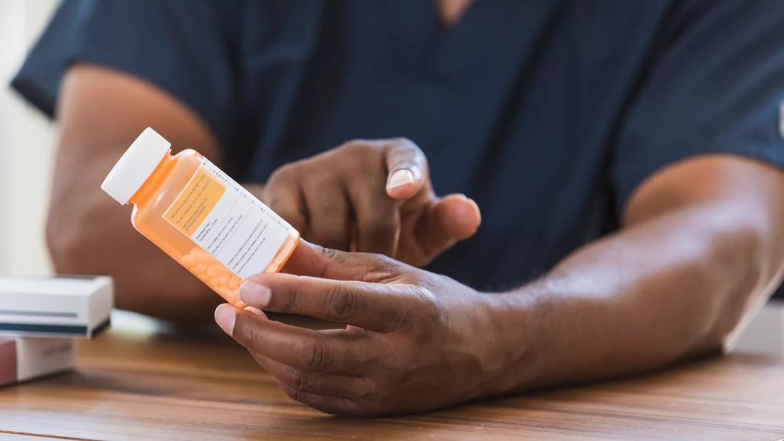 Healthcare provider holding bottle of prescription medication