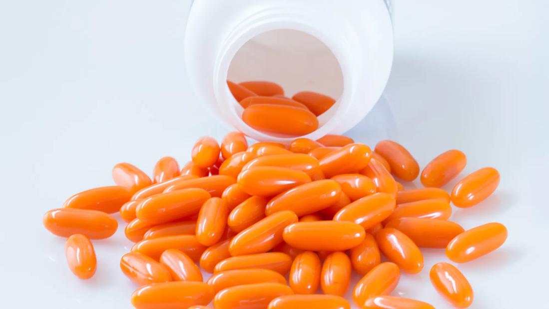 Orange capsules poured out of a bottle