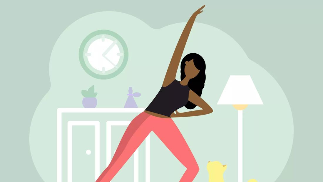 Woman in workout clothes does a lunge stretch in her living room as her cat looks on