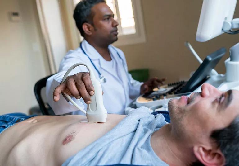 man undergoing echocardiogram with technician