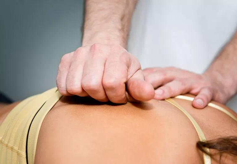 therapist applying myofascial release to back of patient