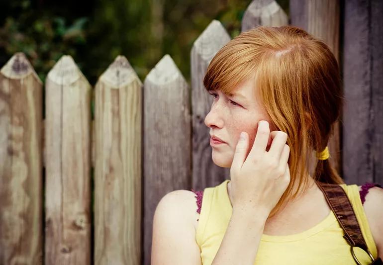 Girl scratching her face