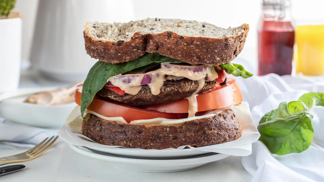 Portobello sandwich with lettuce, tomato, onion and dijon vinaigrette on multigrain bread