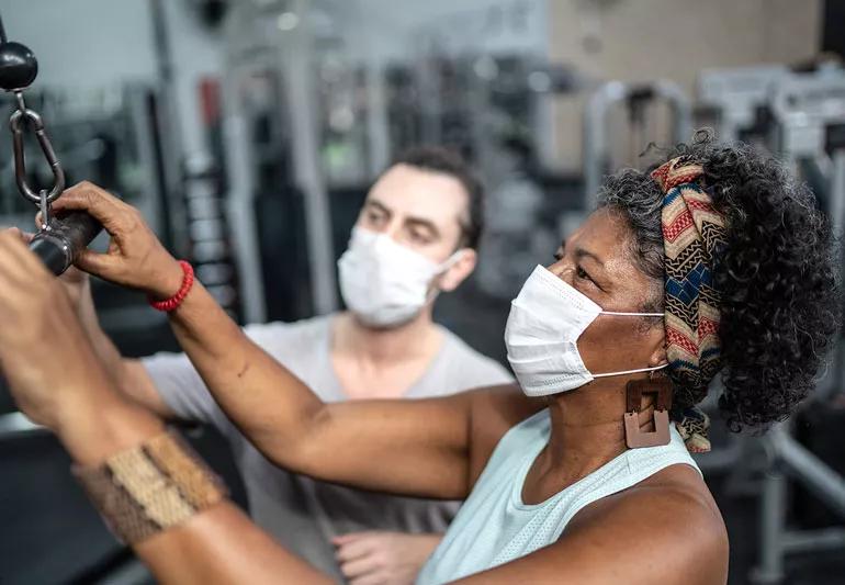 elder woman lifts weights at gym