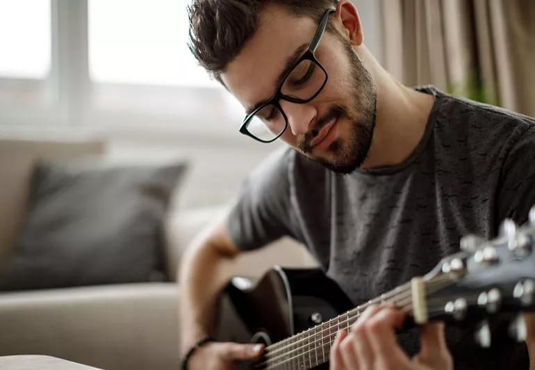 man singing softly and playing guitar