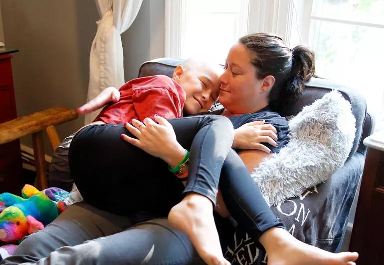 Mom holding child who is going through chemotherapy