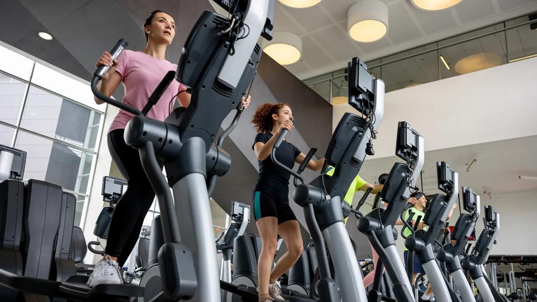 People using elliptical machines in a gym