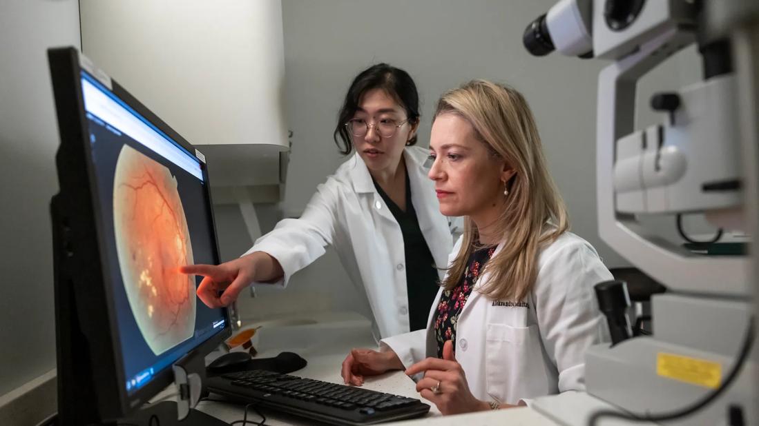 Dr. Rachitskaya and medical student Julia Joo studying an eye on a computer screen