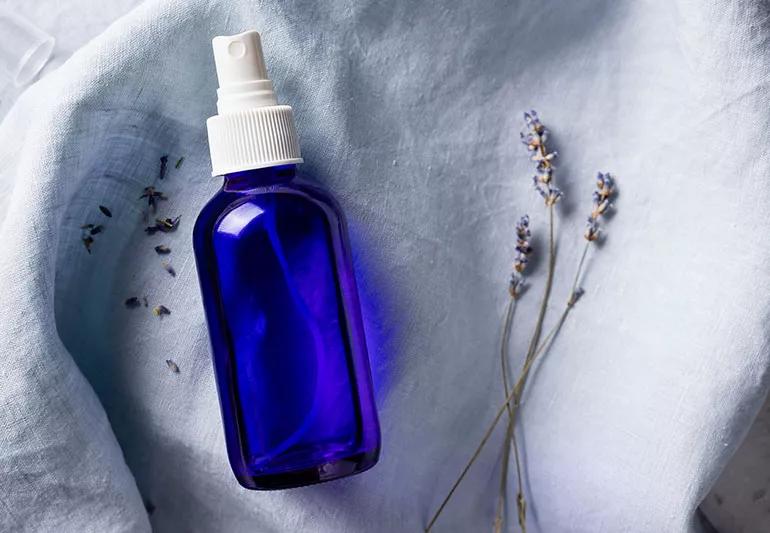 small blue spray bottle and sprigs of lavender