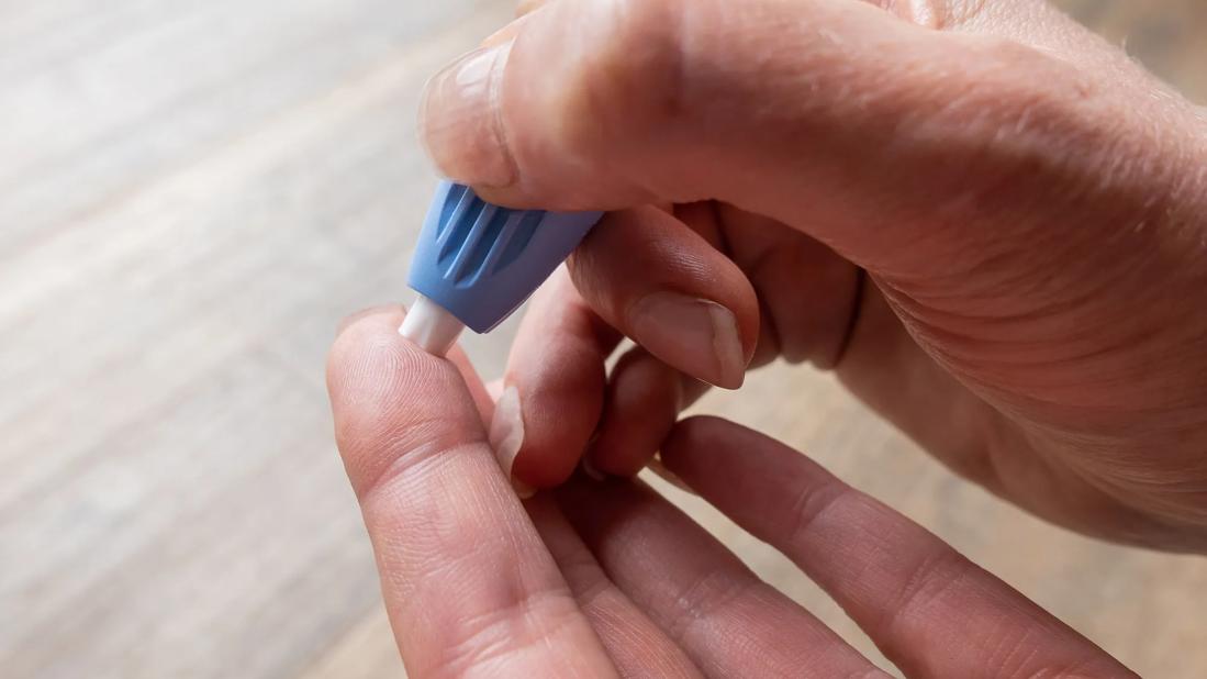 Hands using a finger lanclet to prick finger for blood test