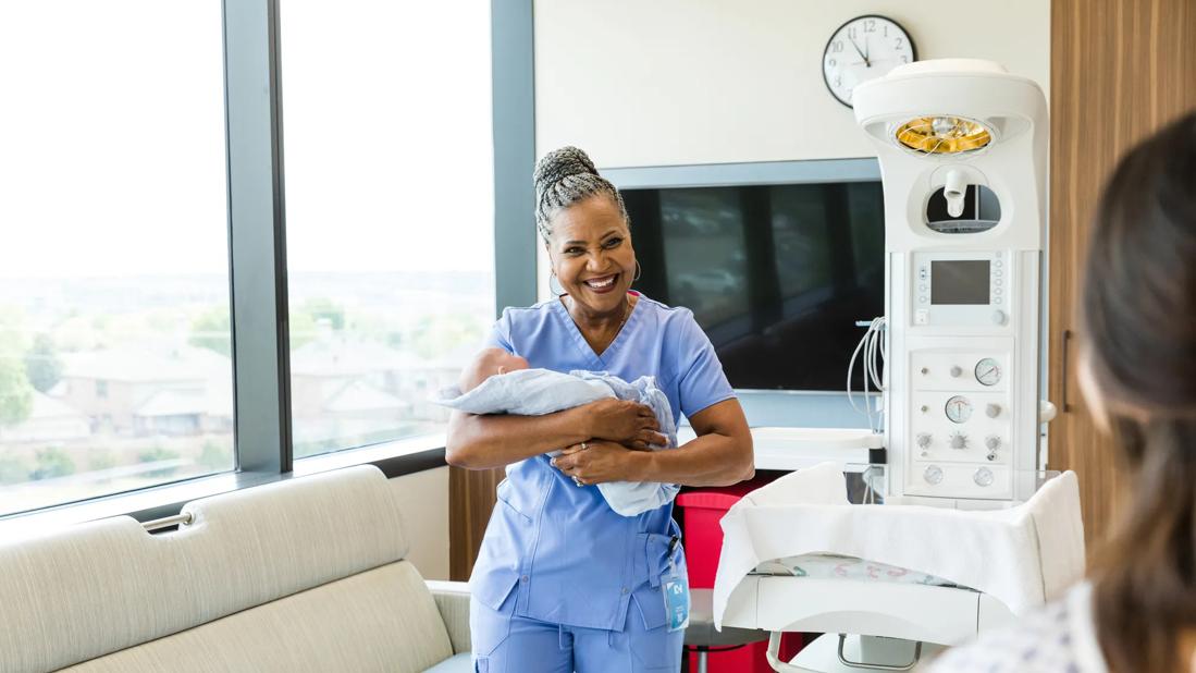 Nurse holding newborn baby