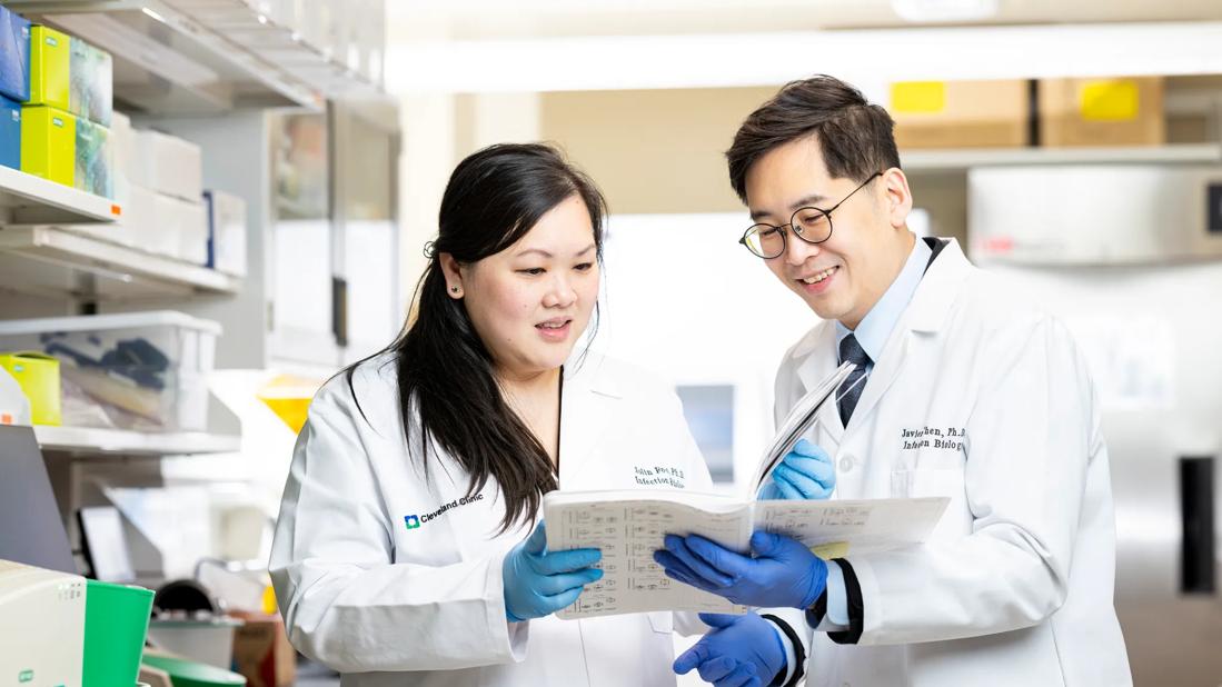 Researchers standing in lab looking at document