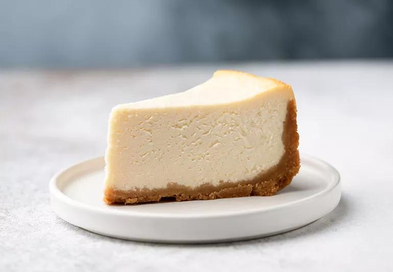A plate with a slice of New York style cheesecake