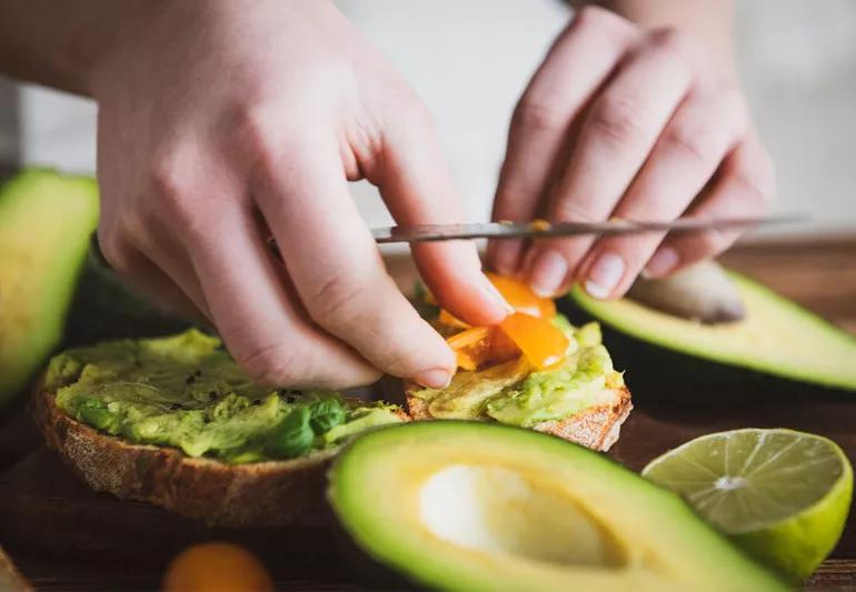Putting avPutting avacado on sandwich a healthy fat source